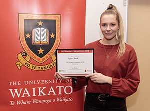 Nyssa Hewitt holding her diploma